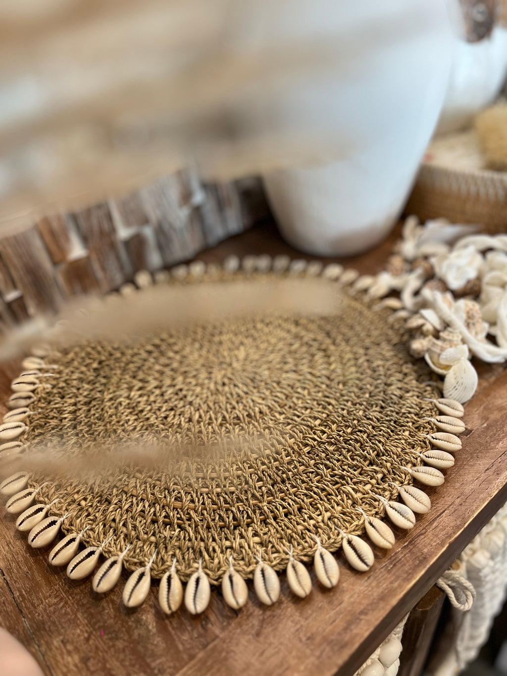 Woven placemat with shell fringe. 34cm