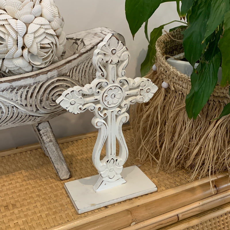 White carved cross on stand.