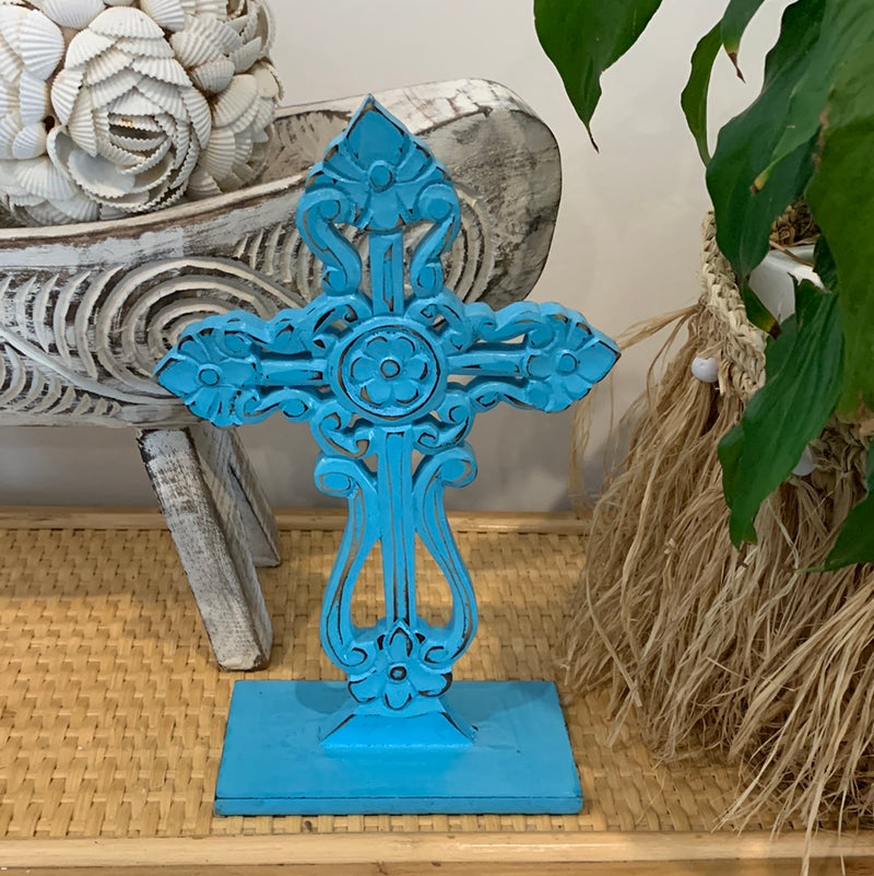 Blue carved cross on stand.